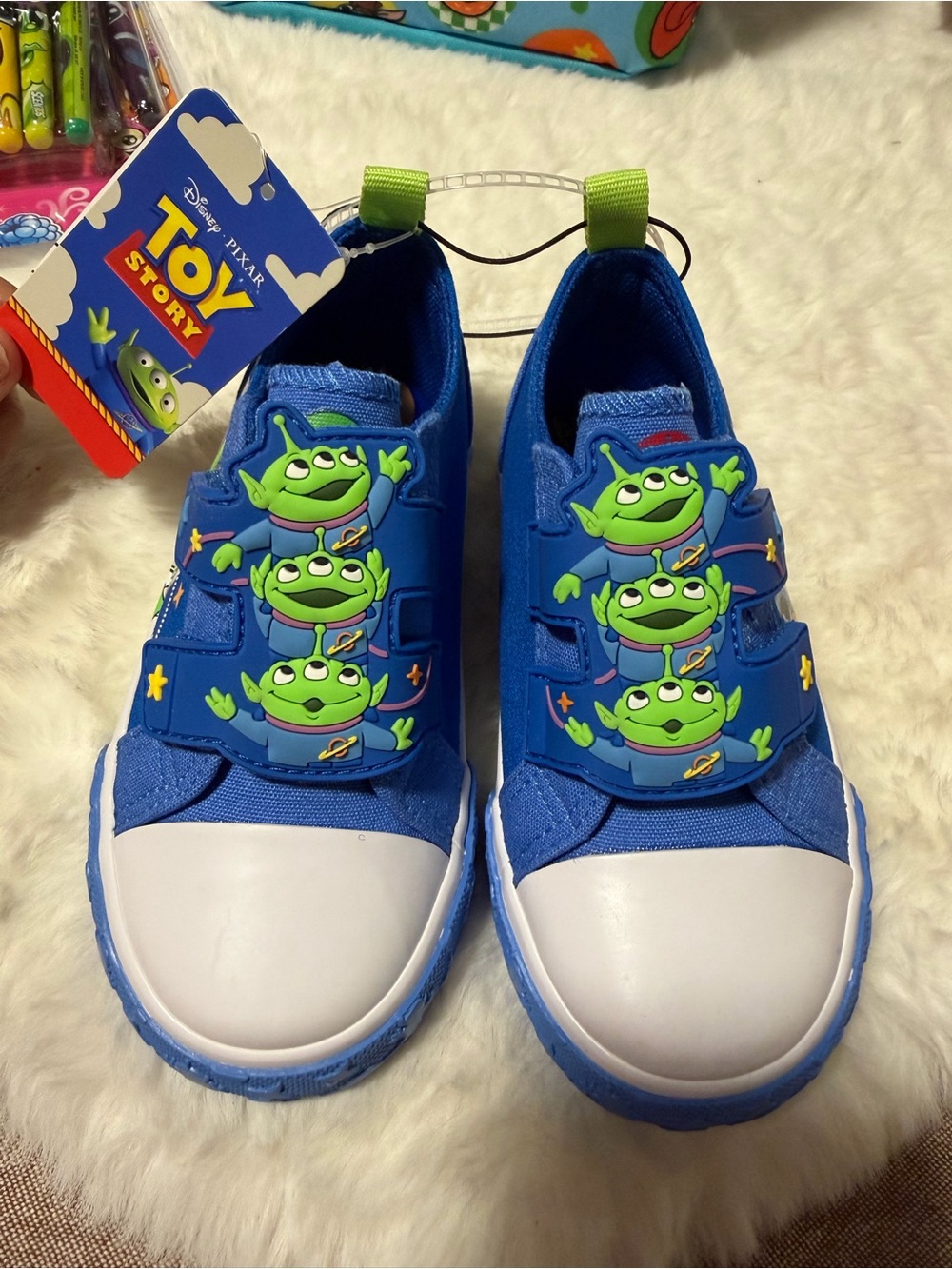These Disney Toy Story Alien toddler shoes feature a blue canvas design with rub